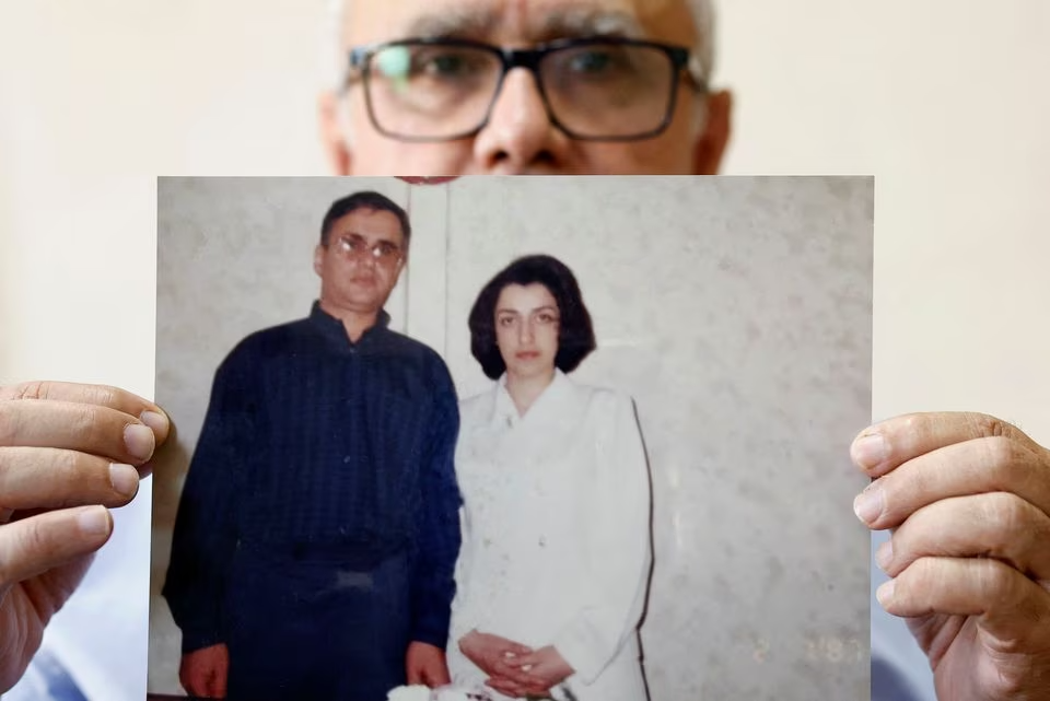 Таги Рамахи, муж Наргес Мохаммади, позирует с недатированной фотографией себя и своей жены во время интервью в Париже.